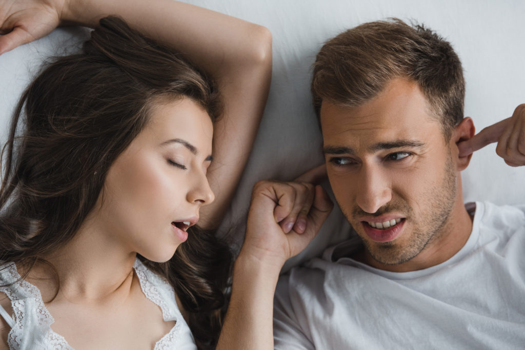 Young woman is snoring and her boyfriend can't sleep