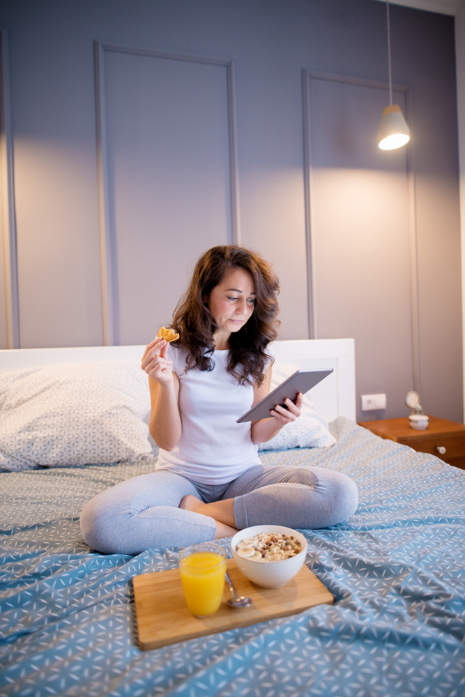 woman eating breakfast in bed
