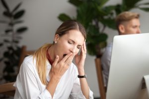 Woman at work experiencing sleep apnea symptoms