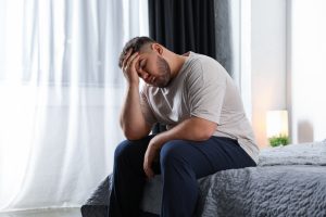 Tired overweight man on bed at home