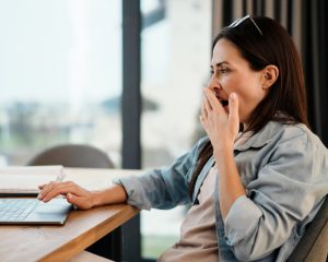 woman yawning at computer