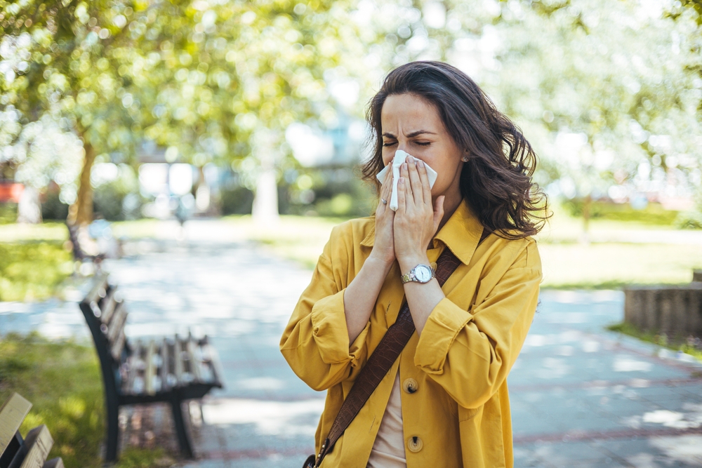 woman in the park blowing her nose