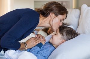 Mother kisses boys forhead before he sleeps - sleep apnea in children