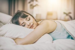 Beautiful woman sleeping peacefully after resolving her sleep apnea symptoms