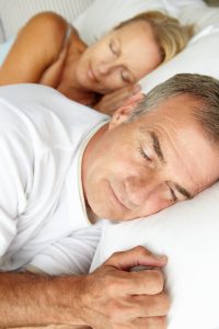 man and woman sleeping side by side in bed